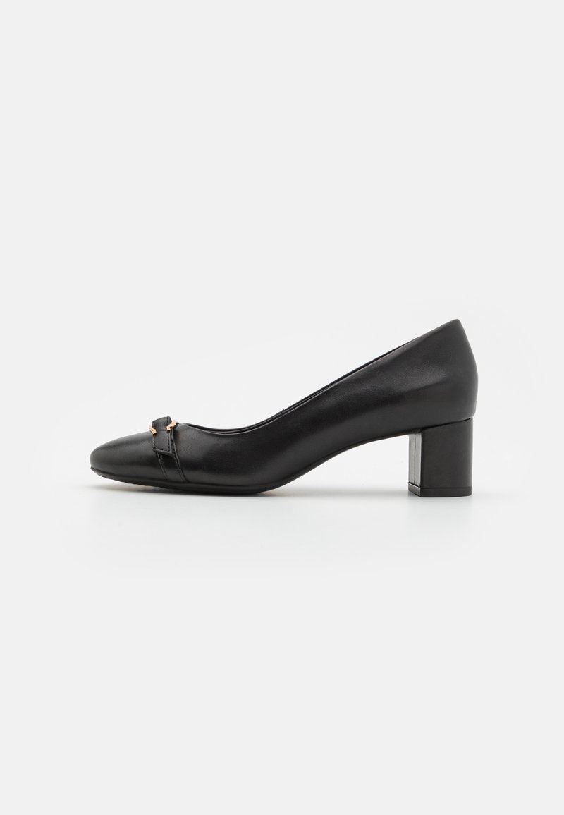 Escarpin en cuir noir avec un bout pointu, doté d'une petite sangle décorative à l'avant et d'un talon carré robuste. Texture lisse.