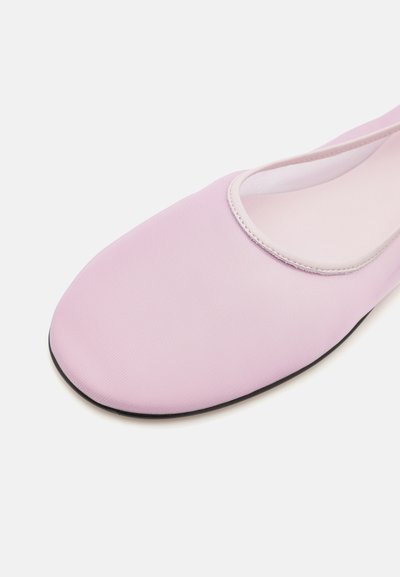 Rosa flad sko med en glat, tekstureret overdel i stof, rund tå og sort gummisål. Har en simpel, elastisk åbning.