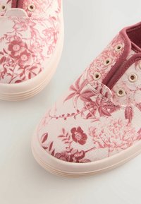 Zapatillas con estampado floral, con un upper de lona en rosa claro, acentos burdeos en contraste, puntera redonda y suela de goma beige.