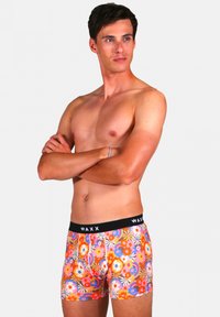 Boxers en stretch pour hommes avec un motif floral multicolore, dotés d'une taille élastique noire avec la marque "WAXX". Le matériau semble doux et lisse.