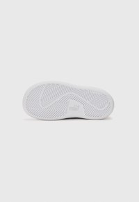 Hvit gummisåle til sneakers med fiskebensmønster, med preget merkevarelogo og ikke-merket tekstur for bedre grep.