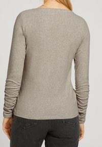 Långärmad, åtsittande skjorta i ljusgrått tyg med en slät yta, med rynkdetalj vid ärmarna och rundad halsringning.