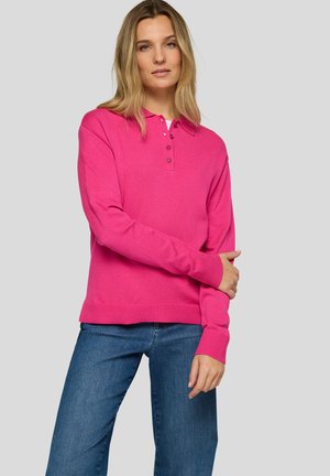 Bright pink knit polo sweater with a ribbed hem and cuffs, featuring a three-button placket. Paired with blue jeans for a casual look.