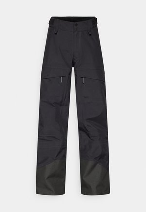 Zwarte waterdichte broek met een losse pasvorm, voorzien van twee voorzakken, een verstelbare taille en donkerder stof bij de enkels voor duurzaamheid.
