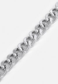 Bracelet en chaîne argentée avec des maillons ovales à la surface poli, espacés uniformément avec une texture lisse et une finition réfléchissante.