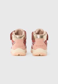 Vue arrière de baskets pour enfants rose et rouge, présentant un matériau en daim, des accents en métal, un col rembourré et une semelle en caoutchouc avec une adhérence texturée.