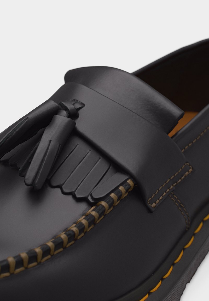 Black leather tassel loafer with detailed fringe and contrast yellow stitching along the sole edge.