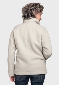 Hellbeige Fleecejacke mit hohem Kragen, strukturiertem Stoff und taillierter Passform, von hinten gezeigt mit sichtbaren Nahtlinien.