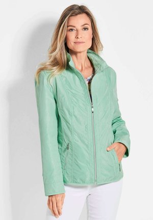 Hellgrüner Zip-Jacke aus glattem, leichtem Stoff, mit Stehkragen, seitlichen Taschen und dezenten Nähdetails.