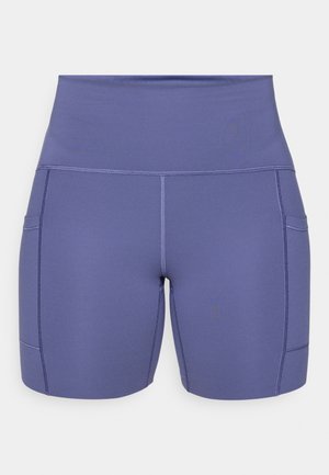 Aukštos juosmens sportinės šortai iš minkštos, tamprios violetinės medžiagos. Yra du šoninės kišenės ir plokščios siūlės, kad būtų patogiau dėvėti.