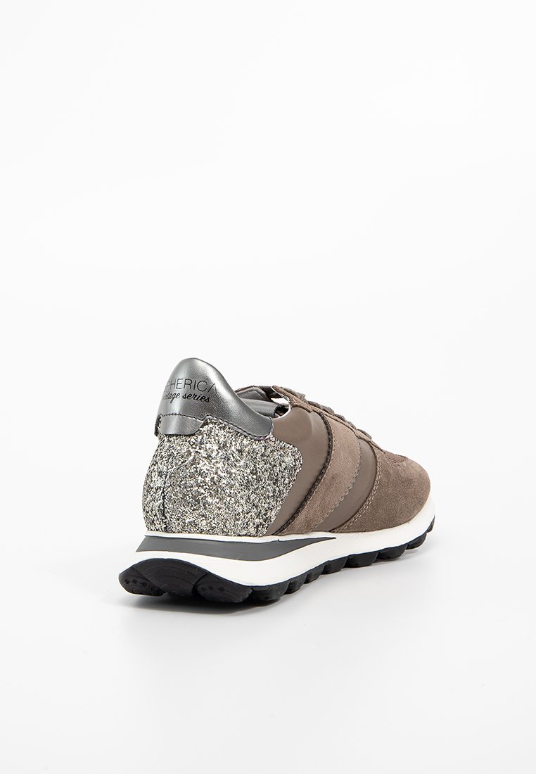 Zapatilla de ante marrón con acentos plateados metálicos, talón brillante y diseño a rayas. Presenta una suela de goma para agarre y soporte.