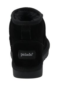 Zwarte enkellaars van suède met een zachte voering, stoffen accenten en een rubberen zool. Achteraan zichtbaar logo-patch boven de zool.