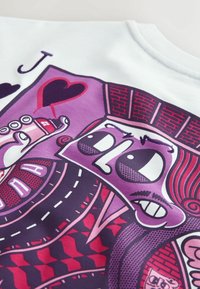 Design der Spielkarte Herz Bube mit einer stilisierten Figur, die eine Spraydose hält und mit geometrischen Mustern in Lila, Rot und Schwarz verziert ist.