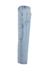 Pantalon de charpentier en denim bleu clair avec poches latérales et arrière, passants de ceinture et une boucle pour marteau sur la jambe droite.