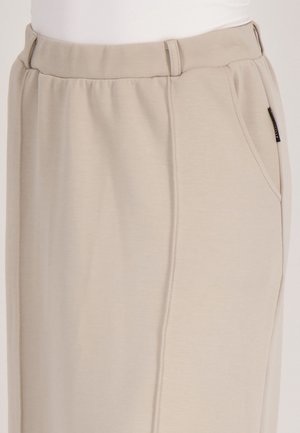 Beige rechte pijpenbroeken van zachte stof met een elastische tailleband, voorzien van zijzakken en een subtiele verticale stiknaad.