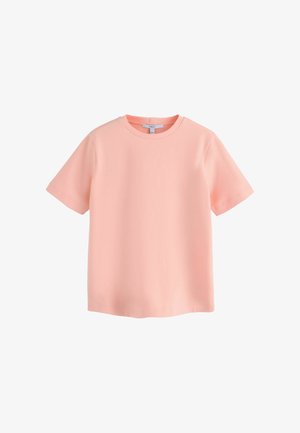 Miękka różowa koszulka z krótkim rękawem i okrągłym dekoltem, z czystymi szwami, pokazana na płasko na białym tle.