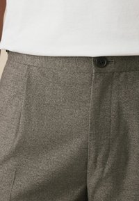 Gray textured trousers with a button closure, featuring side pockets and a tailored fit. The fabric has a subtle heathered pattern.