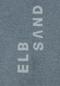 Blauwe stof met de tekst "ELB SAND" in lichte, vetgedrukte letters, verticaal georiënteerd, met een zachte textuur.