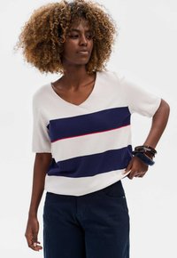 V-hals trui met korte mouwen, voorzien van horizontale marineblauwe en witte strepen met een rode acccent. Zachte gebreide textuur, casual pasvorm.