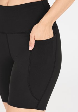Schwarze hochtaillierte Shorts aus dehnbarem Material, mit einer seitlichen Tasche und Flachnähten für zusätzlichen Komfort und Haltbarkeit.