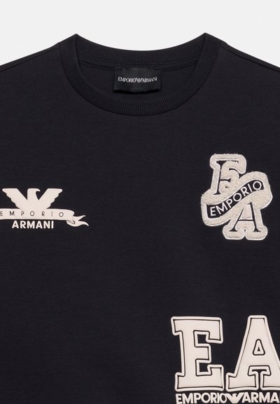 Μαύρο μπλουζάκι Emporio Armani με στρογγυλή λαιμόκοψη, λευκά λογότυπα και κεντημένες ετικέτες με το όνομα της μάρκας και αρχικά στο μπροστινό μέρος.