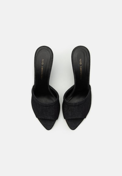 Black denim open-toe mules with pointed toe, textured upper, and smooth black insole. Features a wide, curved strap across the foot.
