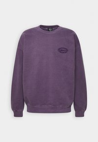 Lila sweatshirt i bomullsblandning, med rundad hals och ribbade ärmslut. Framdelen har en cirkulär logotypapplikation.