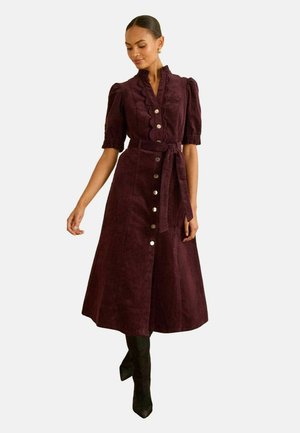 Burgunderrot Cord-Röcke mit kurzen Puffärmeln, Rüschenkragen, vorderen Knöpfen und passendem Gürtel, in einer knieumspielenden A-Linien-Silhouette.