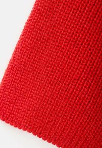 Tissu tricoté rouge avec une texture côtelée, présentant un aspect lisse et doux, mettant en valeur des coutures régulières et une couleur homogène.