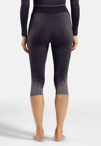 Schwarze und graue Leggings mit gerippter Textur, kniekurzer Länge und einem Ombreeffekt, der von dunkel zu hell verblasst.