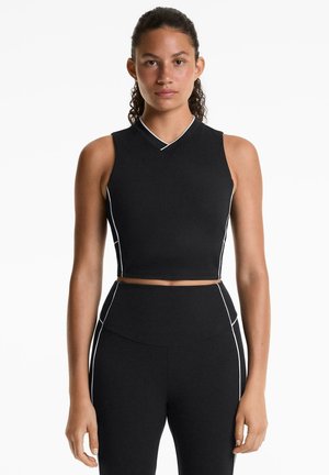 Top sportiv negru, scurt, cu design fără mâneci, decolteu în v și dungi albe accent pe cusături. Fabricat dintr-un material elastic și respirabil.