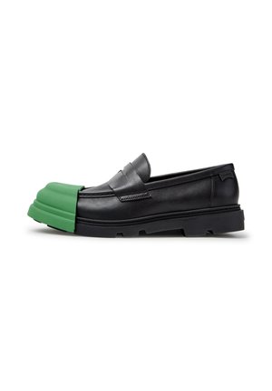 Mocassino in pelle nera con suola spessa, caratterizzato da una copertura protettiva verde staccabile che si estende sulla parte anteriore della scarpa.