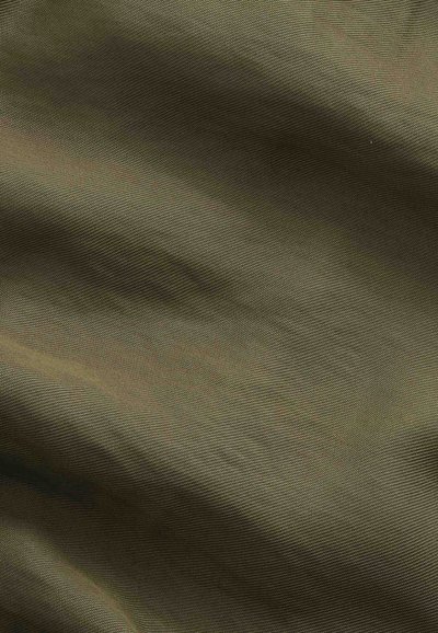 Tissu vert olive lisse avec une texture tissée subtile et des plis délicats créant des ombres douces et des reflets.