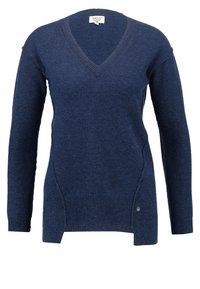 Pull en maille bleu marine avec col en V, manches longues, fentes latérales et ourlet côtelé. Comprend un petit logo en métal sur le côté.