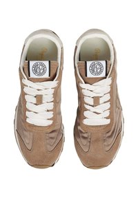 Zapatillas marrones de ante suave con cordones blancos, que presentan un parche de logo redondo y acentos de costura curva en los laterales.