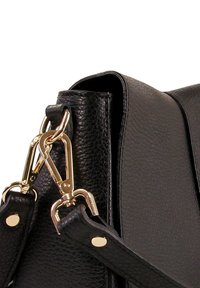 Zwarte leren tas met textuur, voorzien van hardware in goudkleur, waaronder een snap hook en een verstelbare strap. Close-up van het detail van de strapbevestiging.