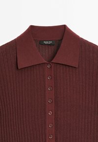 Pull en maille côtelée bordeaux avec col, doté d'une fermeture boutonnée à l'avant avec six boutons marron et une étiquette portant la mention "Massimo Dutti".