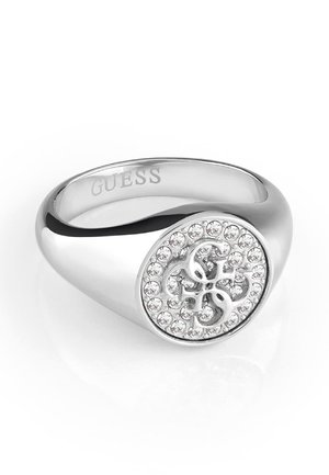Bague chevalière Guess en argent avec visage rond orné de cristaux clairs et logo G entrelacé, anneau poli et lisse.