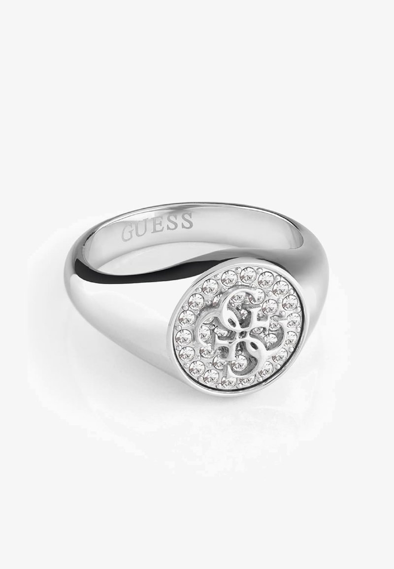 Bague chevalière Guess en argent avec visage rond orné de cristaux clairs et logo G entrelacé, anneau poli et lisse.