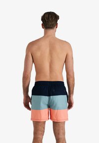 Mannen zwemshorts met een kleurbereik ontwerp in marineblauw, teal en koraal. Elastische tailleband met koord, gladde stof en knielengte.