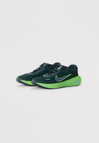 Nike do biegania z ciemnozieloną siateczkową cholewką, neonowozieloną podeszwą środkową i fioletowym logo swoosh. Niski profil z zapięciem na sznurowadła.
