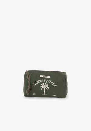 Pochette rectangulaire en tissu vert avec fermeture éclair, cordon décoratif, motif palmier blanc et texte « Sunset Lover The Beach Club ».