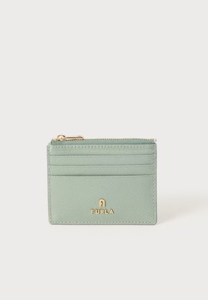 Petit porte-cartes en cuir vert clair avec trois emplacements pour cartes, un compartiment à monnaie zippé et un logo Furla doré sur le devant.