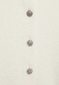 Tre bottoni rotondi argentati con strass trasparenti disposti verticalmente su uno sfondo di morbido tessuto bianco.