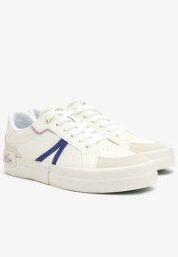 Baskets en cuir blanc avec des accents violets et bleus, côtés texturés et col rembourré, arborant un logo de marque proéminent sur le talon.