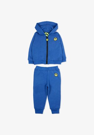Felpa con cappuccio e zip per bambini di colore blu e pantaloni abbinati con vita elastica, entrambi con toppe a forma di faccina sorridente gialla.