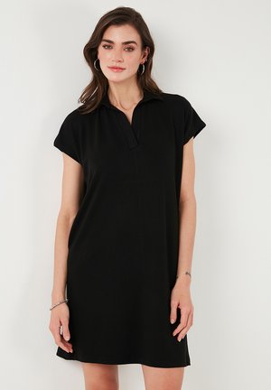 Black polo dress with a short collar and cap sleeves. Smooth, lightweight fabric with a relaxed fit and solid black color.