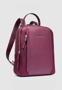 Bordeauxroter Leder-Rucksack mit schlankem Design, Reißverschluss, Fronttasche und verstellbaren Riemen. Verfügt über silberne Beschläge und Logodetails.