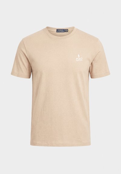 Beige kortermet t-skjorte med rund hals og liten hvit Polo Ralph Lauren-logo på venstre bryst mot en ensfarget bakgrunn.