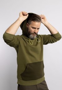 Sudadera de color verde oliva con capucha ajustable mediante cordón, bolsillo frontal, puños y bajo acanalados. El material es suave y liso, con un acabado texturizado.